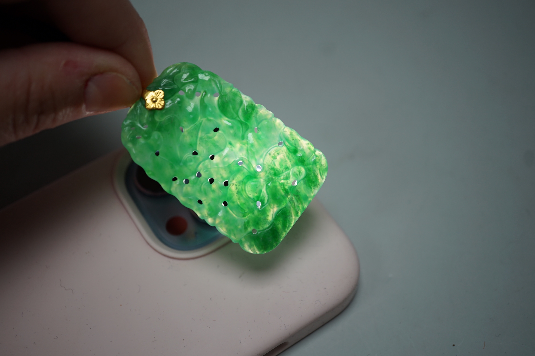 A carved Chinese jadeite pendant with pierced decoration. 5.5 x 3cm